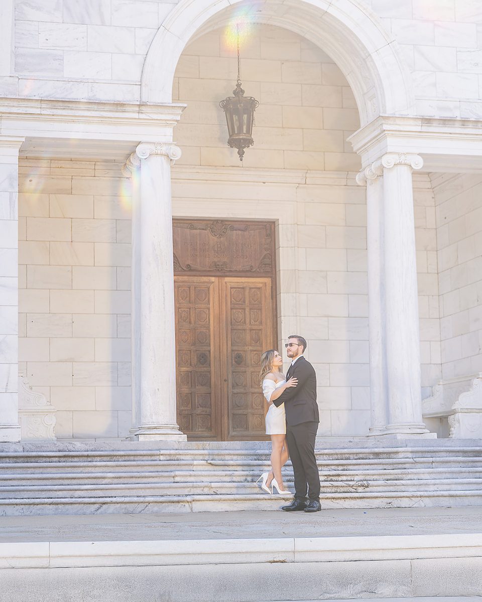 Engaged couple framed by the archway of the Brooks Museum of Art, Memphis