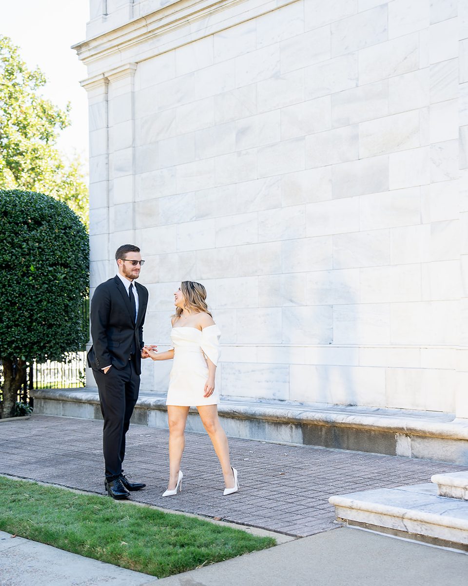 Engaged couple beside the marble wall of the Brooks Museum of Art, Memphis