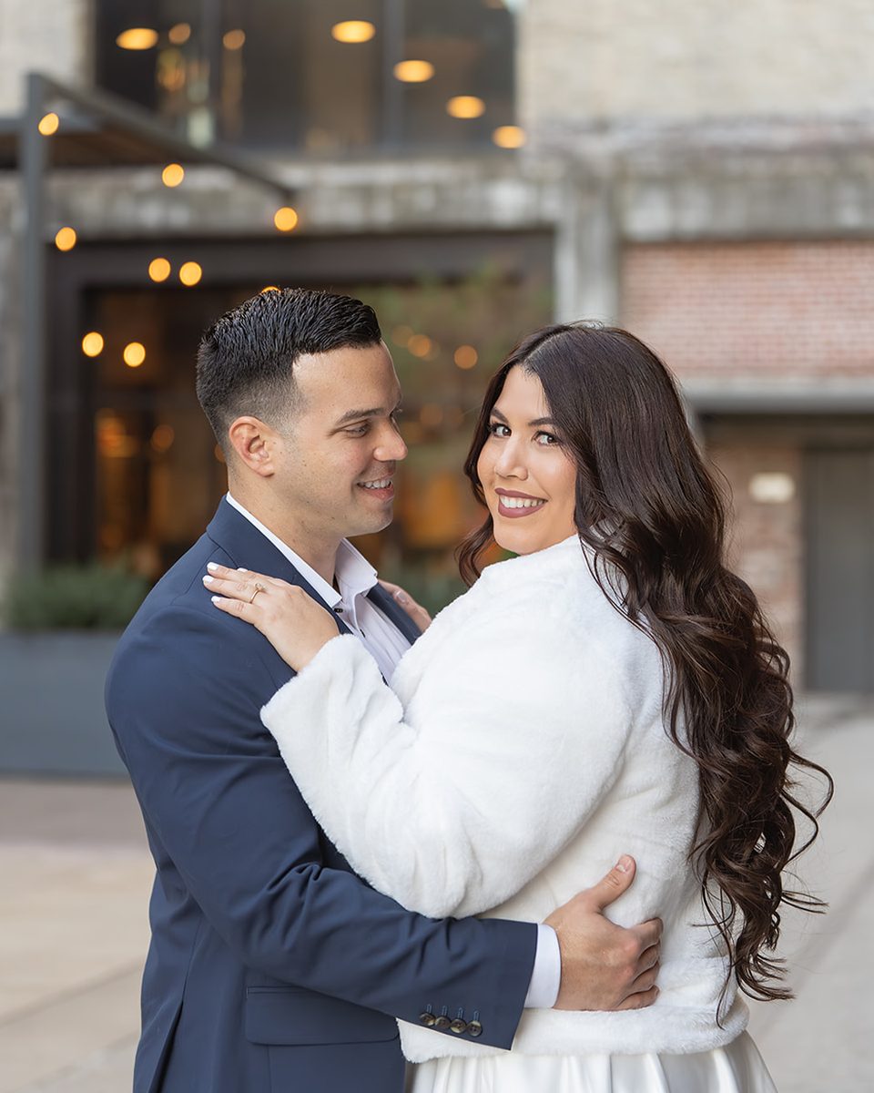 Engaged couple embracing under city lights at Crosstown Concourse, Memphis