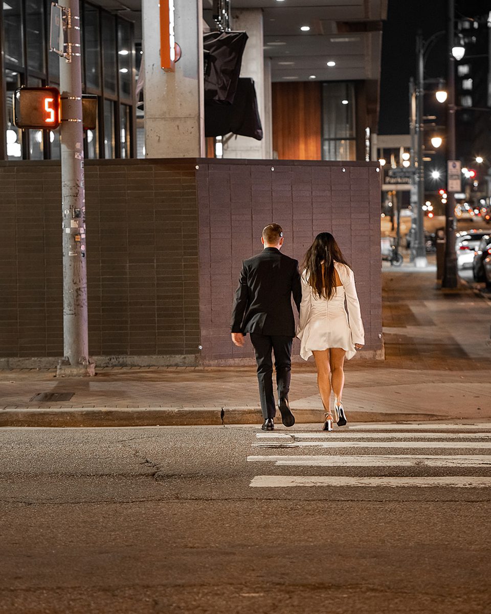 Engaged couple crossing the street in Downtown Memphis at night