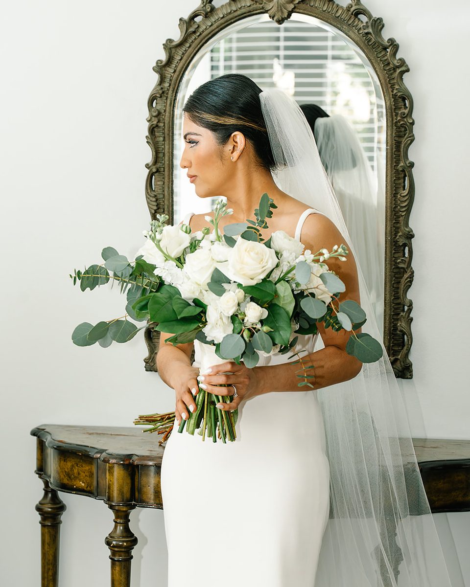 Bride with her bouquet by a gold mirror at a Harbor Town Memphis wedding