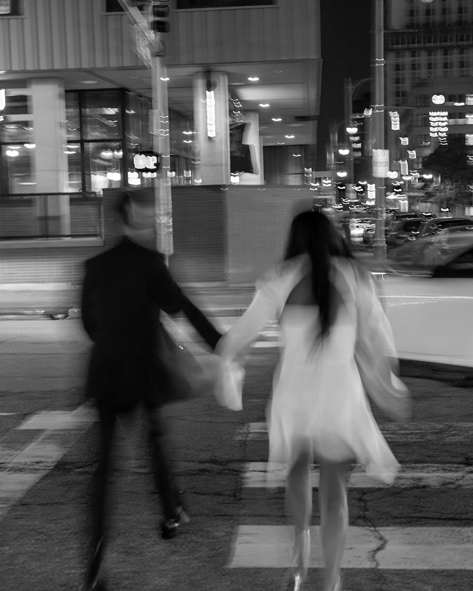 Engaged couple running hand in hand on Main Street, Memphis, black and white