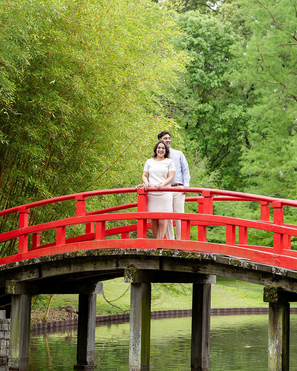 Engaged couple on the red bridge at Memphis Botanic Garden
