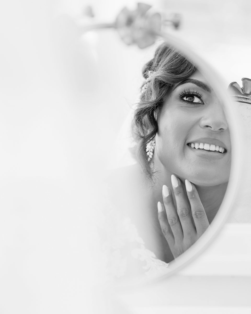 Black and white bride smiling behind her veil