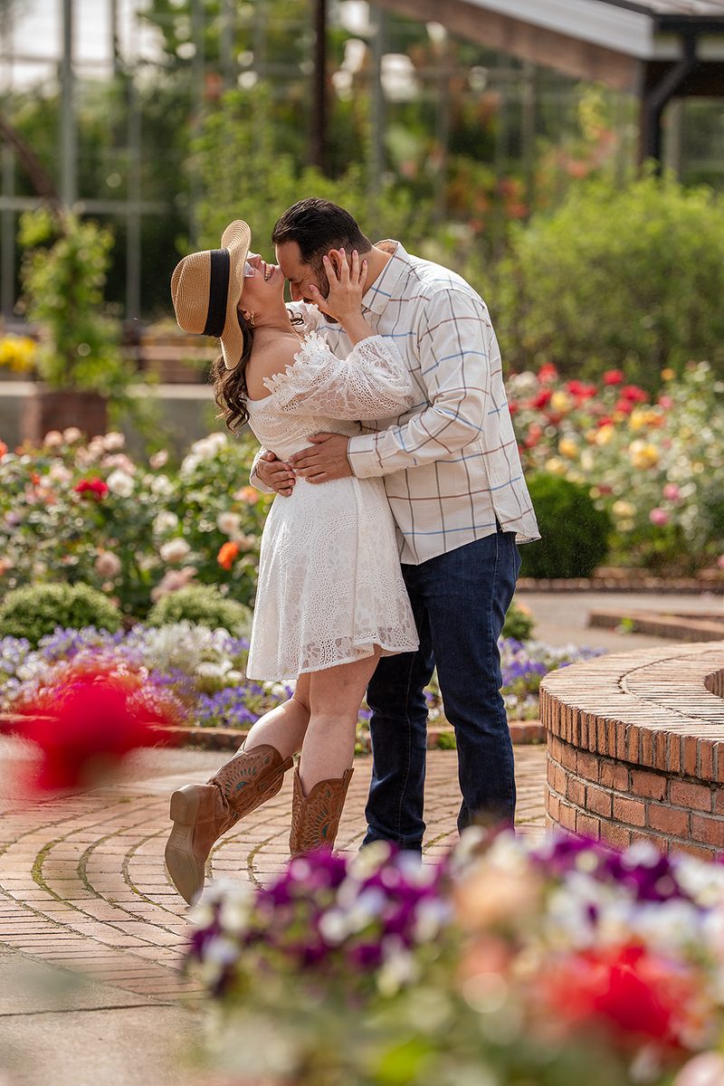Engaged couple kissing in a Memphis garden