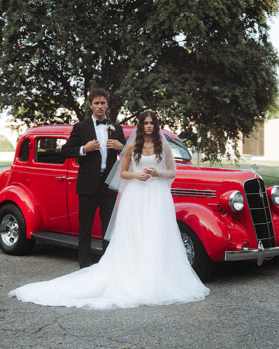 Elopement couple beside a vintage red car at the Pink Palace Mansion, Memphis
