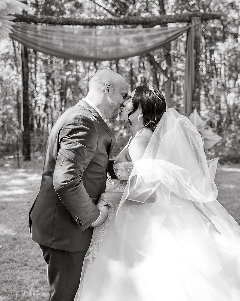 Wedding ceremony under a draped arch at a Southaven estate, black and white