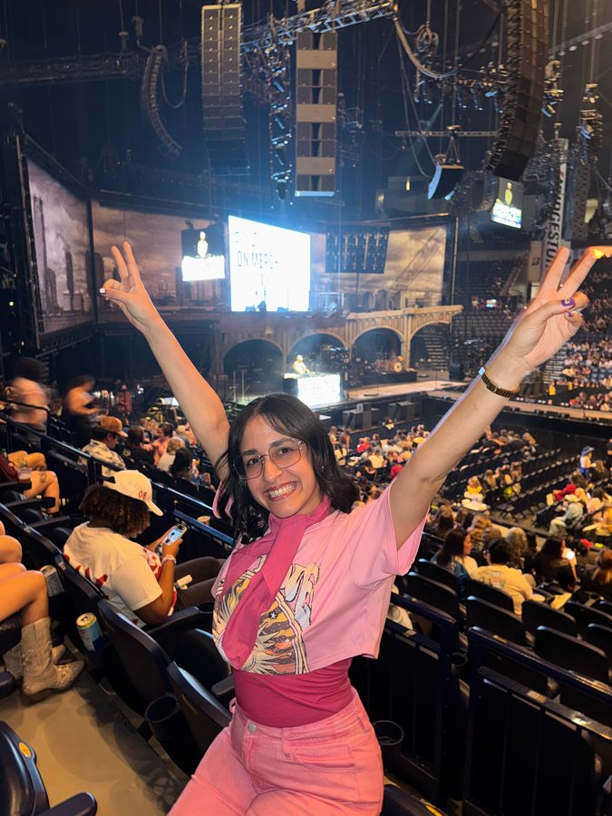 Virginia Puche with her hands up at a concert
